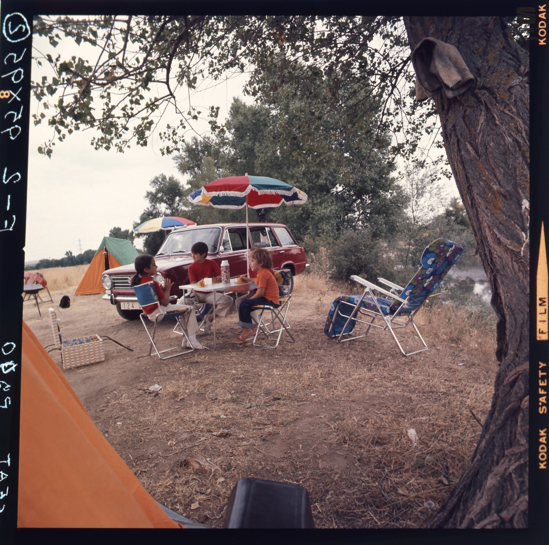 Foto de archivo: niños merendando junto a un SEAT 124 familiar en un camping